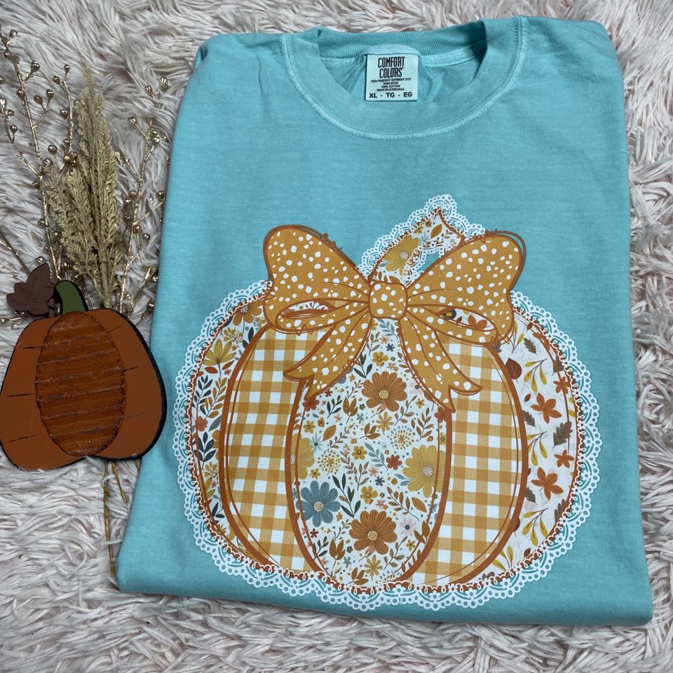 Folded blue shirt with a decorative pumpkin design on a textured surface