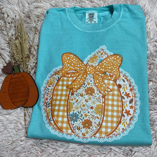 Folded blue shirt with a decorative pumpkin design on a textured surface