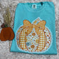 Folded blue shirt with a decorative pumpkin design on a textured surface