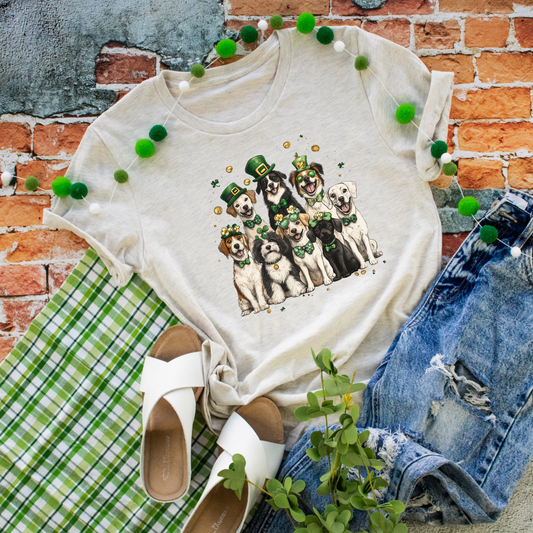 Heather natural graphic tee featuring a group of festive dogs wearing leprechaun hats and St. Patrick’s Day accessories.